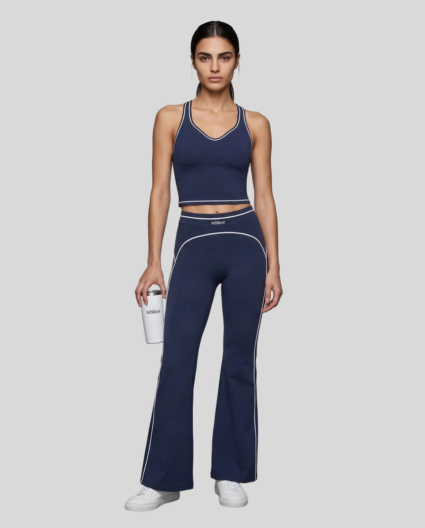 Front angled full body view of a model wearing the TrackLine Outline Flared Pants in Navy Blue