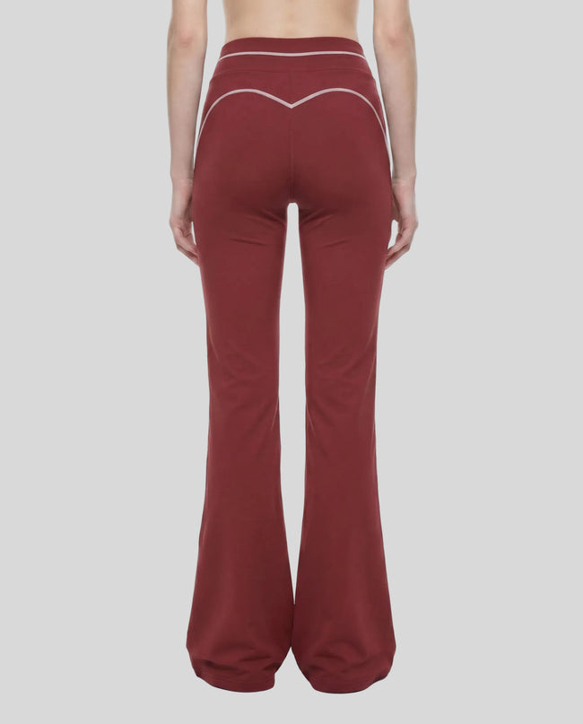 Back view of a model wearing the TrackLine Outline Flared Pants in Red