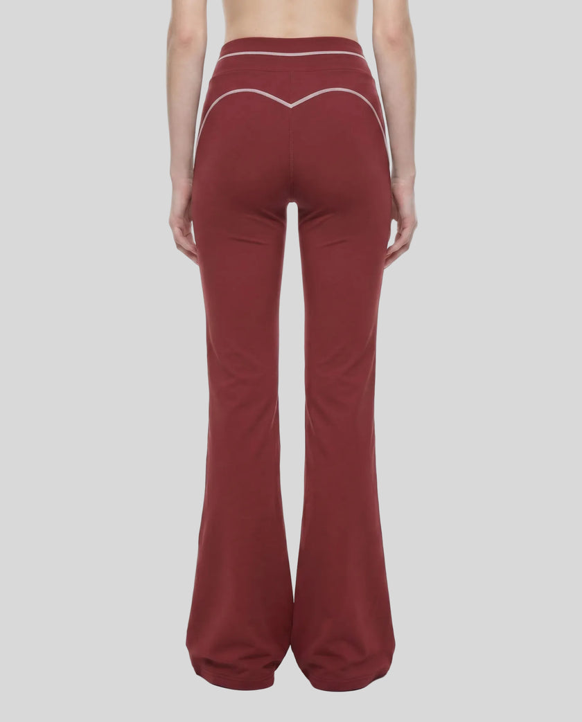 Back view of a model wearing the TrackLine Outline Flared Pants in Red