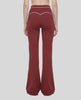 Back view of a model wearing the TrackLine Outline Flared Pants in Red