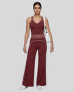 Front angled full body view of a model wearing the TrackLine Outline Flared Pants in Red