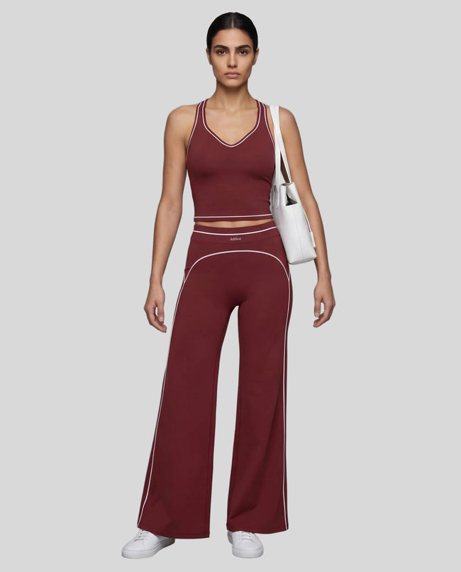 Front angled full body view of a model wearing the TrackLine Outline Flared Pants in Red