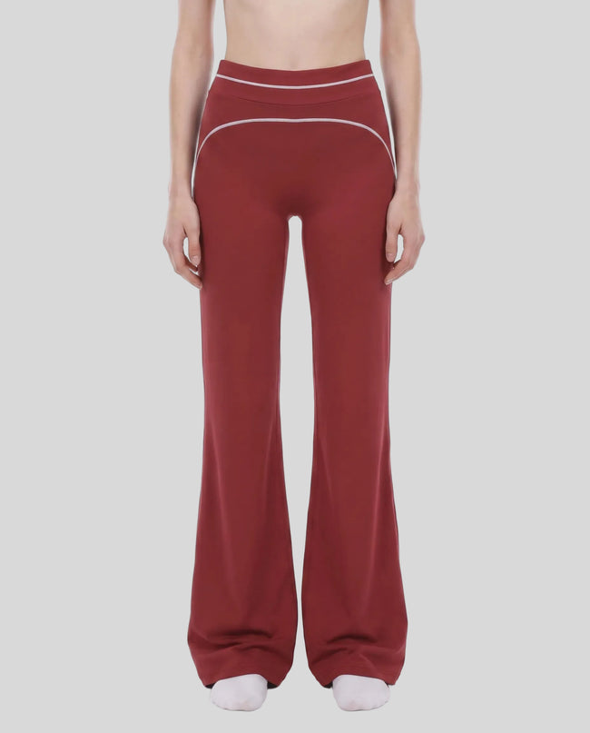 Model wearing the TrackLine Outline Flared Pants in Red viewed from the front