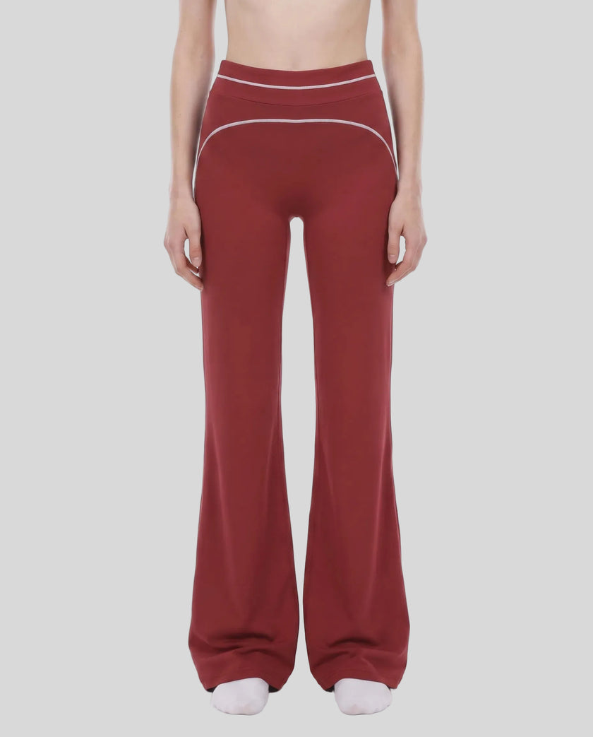 Model wearing the TrackLine Outline Flared Pants in Red viewed from the front