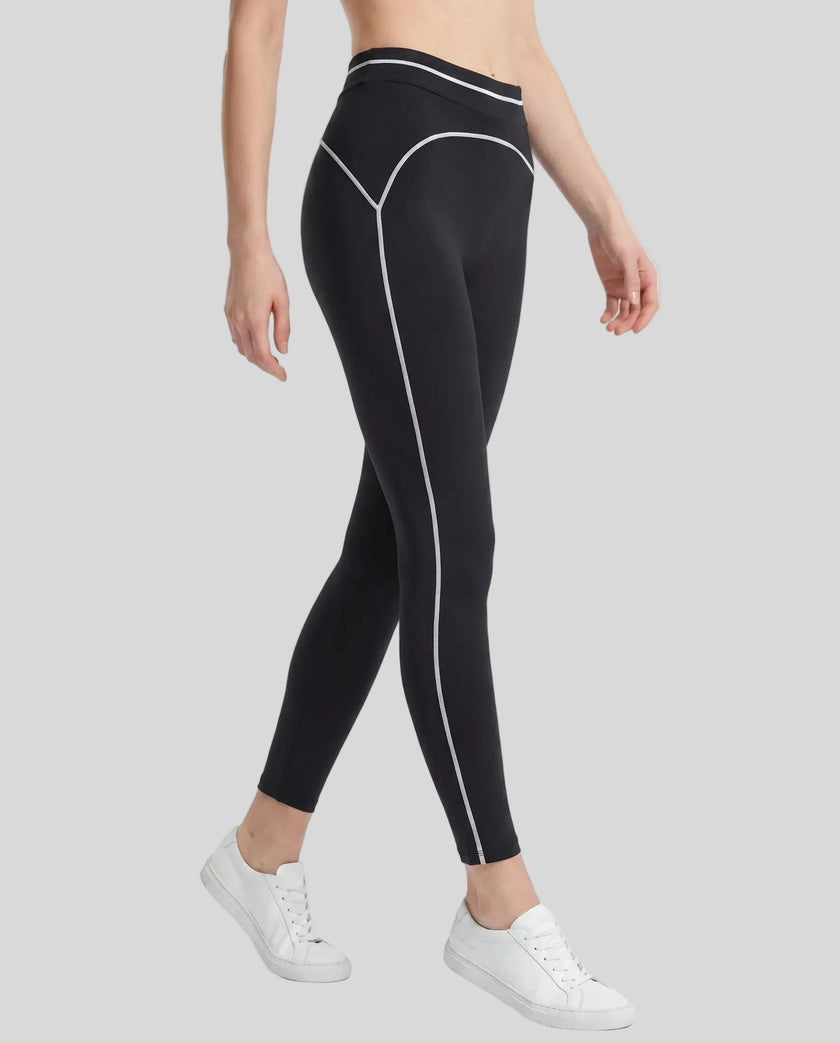 Side angled view of a model wearing the TrackLine Outline Leggings in Black