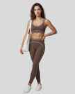 Front angled full body view of a model wearing the TrackLine Outline Leggings in Coffee
