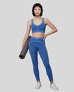 Front angled full body view of a model wearing the TrackLine Outline Leggings in Colorful Blue