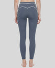 Back view of a model wearing the TrackLine Outline Leggings in Haze Blue