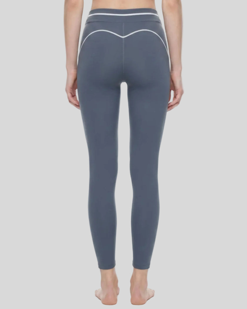 Back view of a model wearing the TrackLine Outline Leggings in Haze Blue
