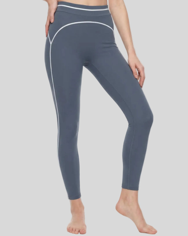 Front angled view of a model wearing the TrackLine Outline Leggings in Haze Blue