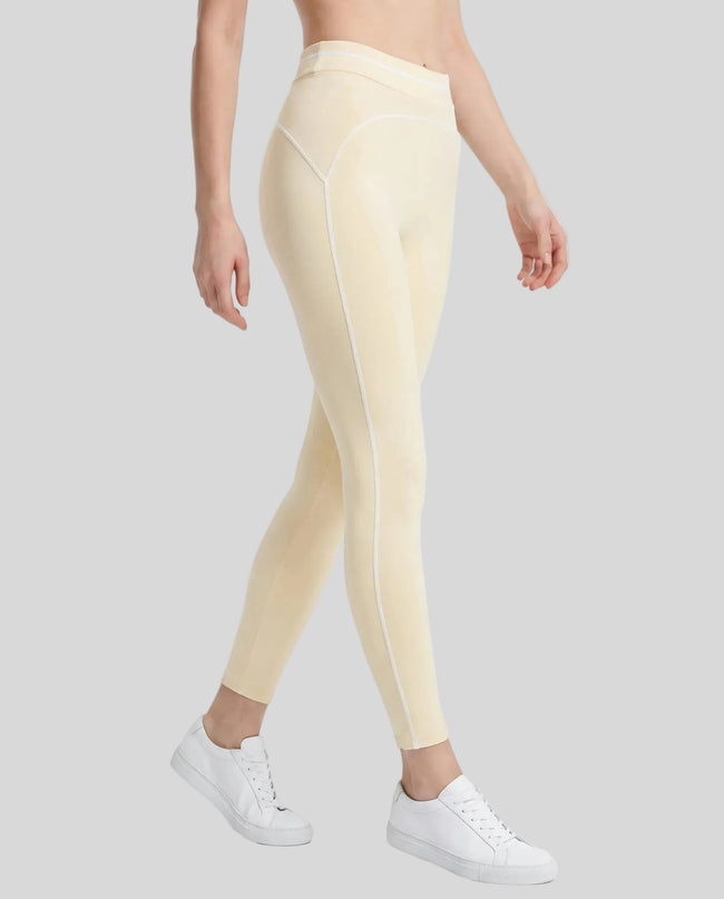 Side angled view of a model wearing the TrackLine Outline Leggings in Light Apricot
