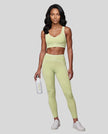 Front angled full body view of a model wearing the TrackLine Outline Leggings in Light Green