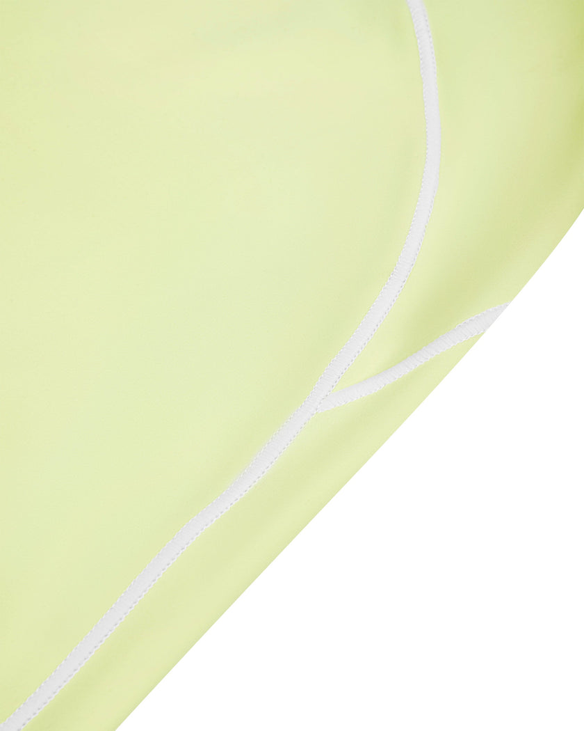 Side close-up of the TrackLine Outline Leggings in Light Green highlighting the contrast piping detail