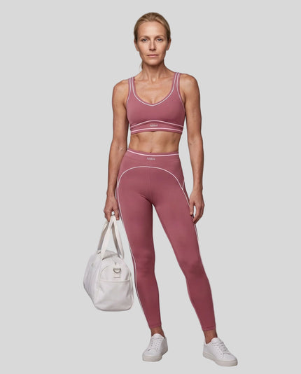 Front angled full body view of a model wearing the TrackLine Outline Leggings in Purple