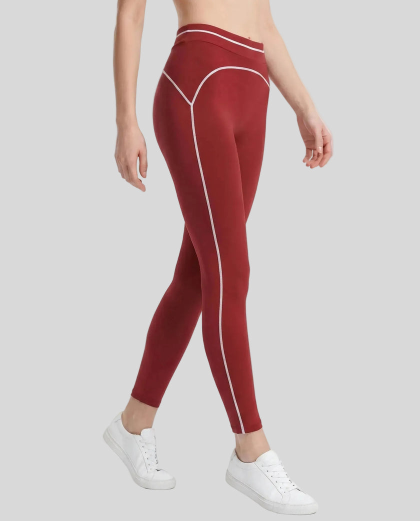 Side angled view of a model wearing the TrackLine Outline Leggings in Red