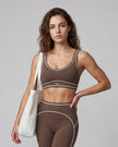 Model wearing the TrackLine Outline Sports Bra in Coffee viewed from the front