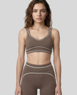 Model wearing the TrackLine Outline Sports Bra in Coffee viewed from the front