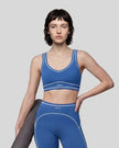 Model wearing the TrackLine Outline Sports Bra in Colorful Blue viewed from the front