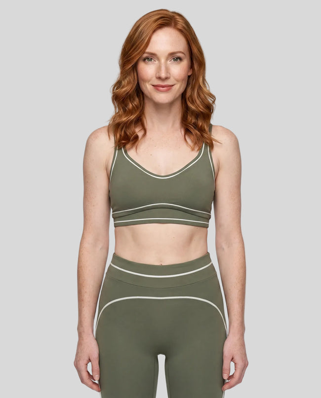 Model wearing the TrackLine Outline Sports Bra in Gray Green viewed from the front