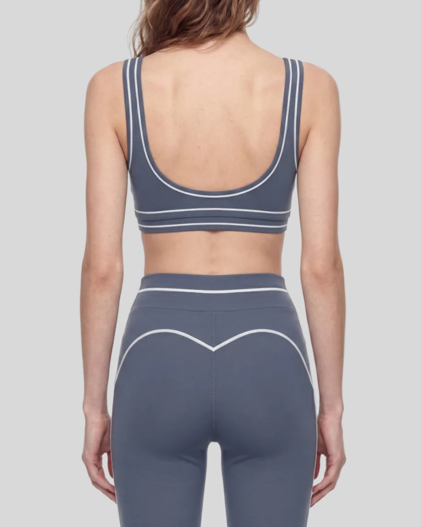 Back view of a model wearing the TrackLine Outline Sports Bra in Haze Blue