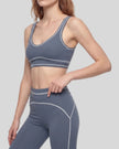 Front angled view of a model wearing the TrackLine Outline Sports Bra in Haze Blue