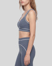 Side view of a model wearing the TrackLine Outline Sports Bra in Haze Blue