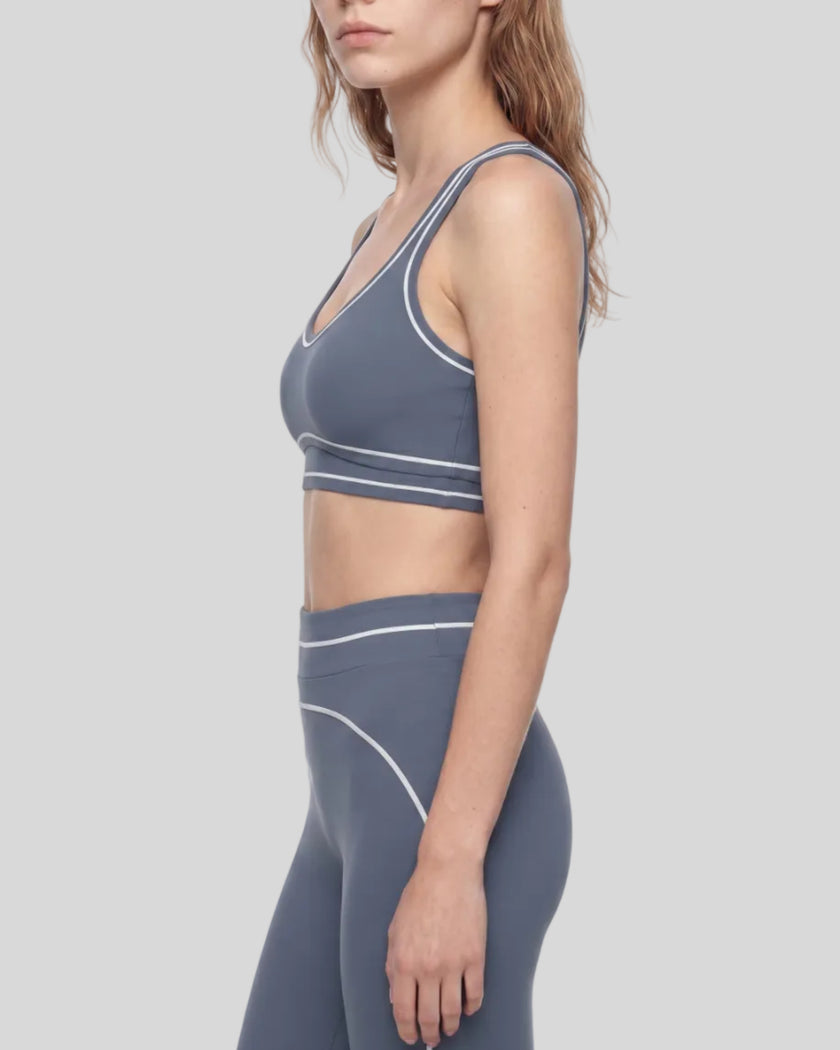 Side view of a model wearing the TrackLine Outline Sports Bra in Haze Blue