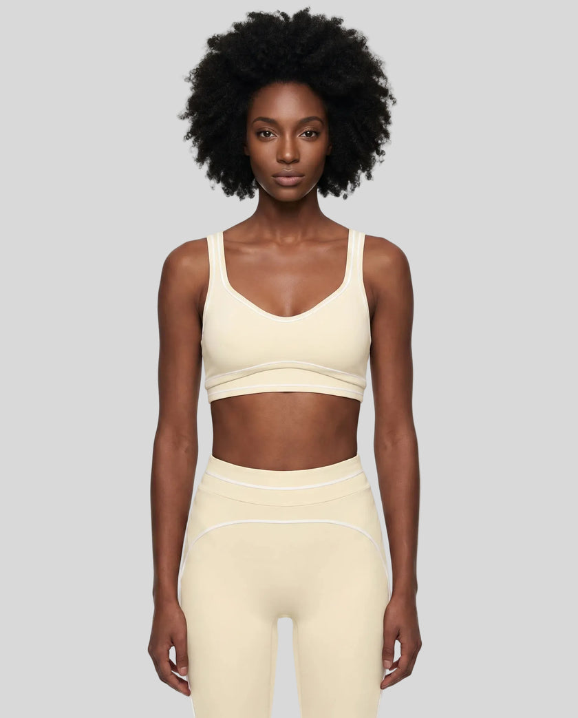 Model wearing the TrackLine Outline Sports Bra in Light Apricot viewed from the front