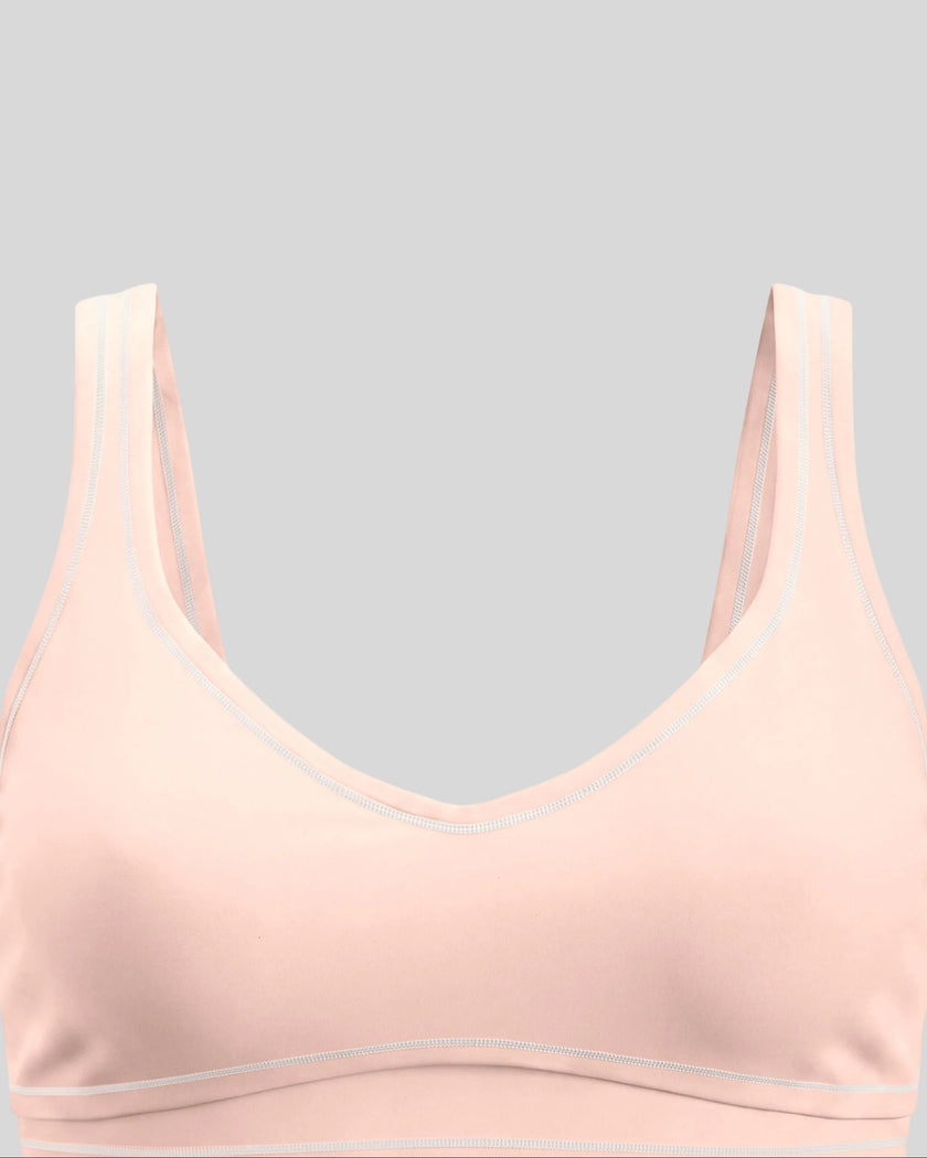 Close-up of the front neckline and contrast piping on the TrackLine Outline Sports Bra in Light Pink