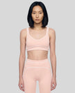 Model wearing the TrackLine Outline Sports Bra in Light Pink viewed from the front