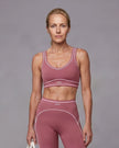 Model wearing the TrackLine Outline Sports Bra in Purple viewed from the front