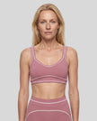 Model wearing the TrackLine Outline Sports Bra in Purple viewed from the front