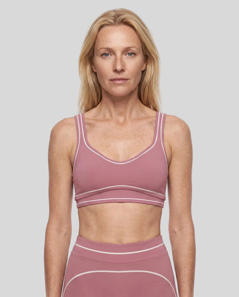 Model wearing the TrackLine Outline Sports Bra in Purple viewed from the front