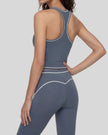 Back angled view of a model wearing the TrackLine Outline Tank Top in Haze Blue
