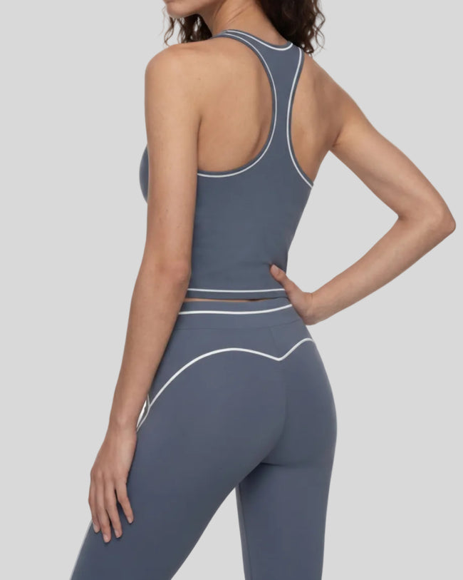 Back angled view of a model wearing the TrackLine Outline Tank Top in Haze Blue