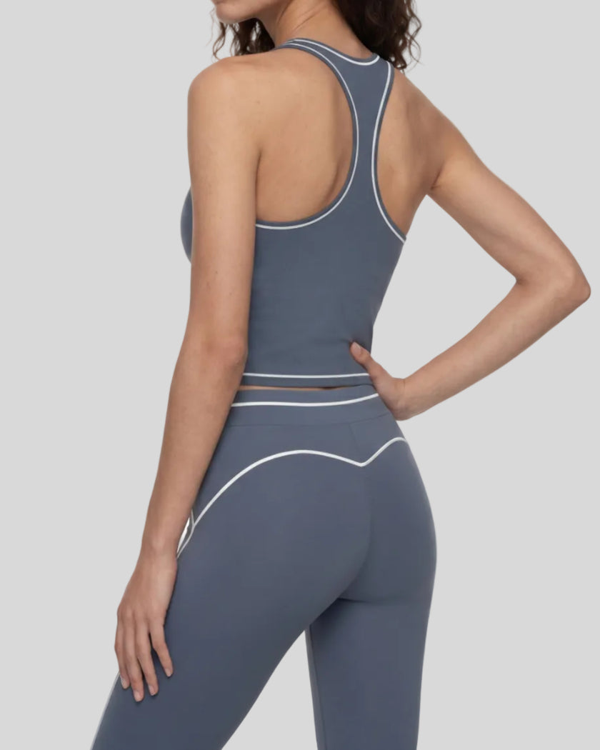 Back angled view of a model wearing the TrackLine Outline Tank Top in Haze Blue