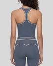 Back view of a model wearing the TrackLine Outline Tank Top in Haze Blue