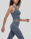 Side angled view of a model wearing the TrackLine Outline Tank Top in Haze Blue