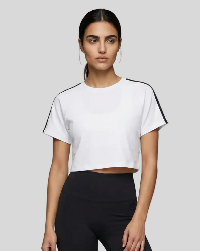 Upper body front view of a woman wearing the Athlesi TrackLine Performance Crop Tee in white