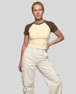 Woman wearing the TrackLine Raglan Baby Tee in Apricot with Coffee from the front showing its fitted cropped silhouette