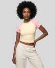 Woman wearing the TrackLine Raglan Baby Tee in Apricot with Pink from the front showing its fitted cropped silhouette