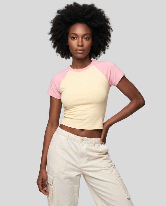 Woman wearing the TrackLine Raglan Baby Tee in Apricot with Pink from the front showing its fitted cropped silhouette