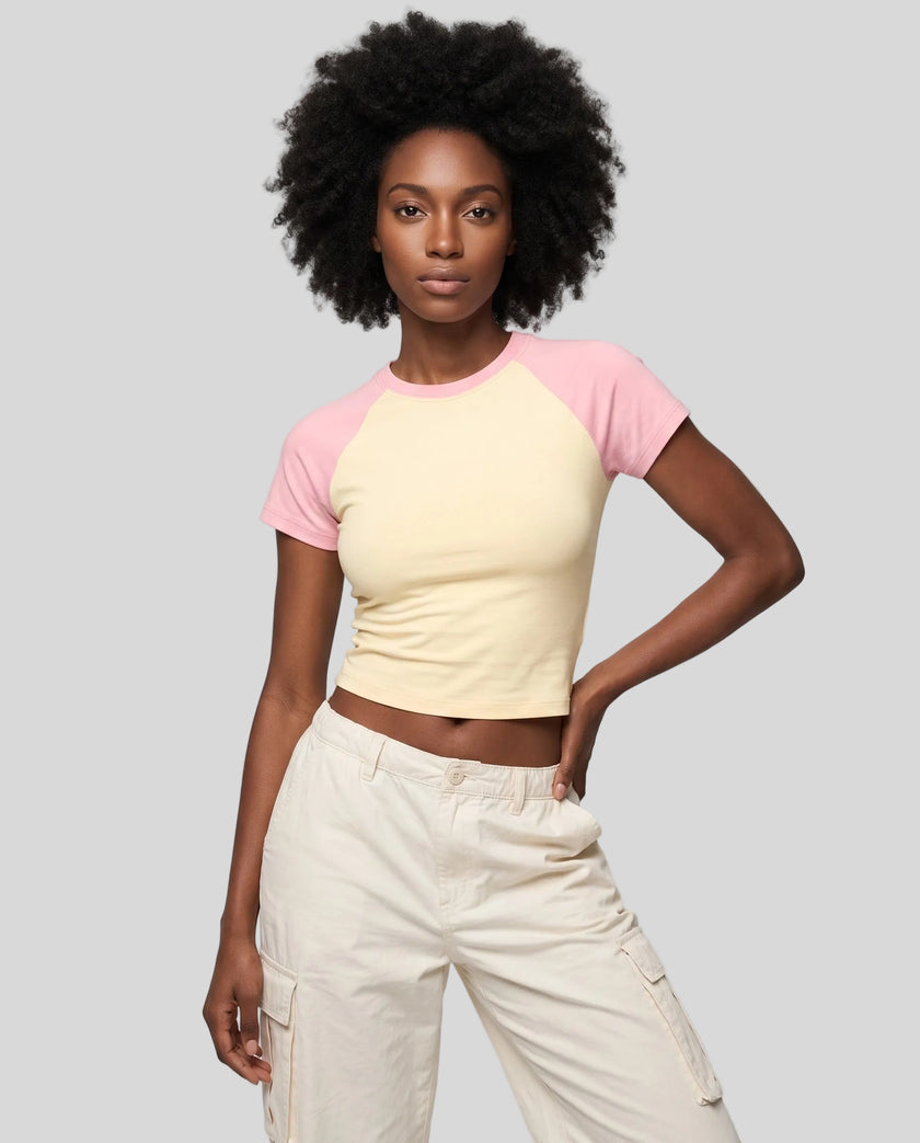 Woman wearing the TrackLine Raglan Baby Tee in Apricot with Pink from the front showing its fitted cropped silhouette