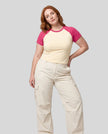 Woman wearing the TrackLine Raglan Baby Tee in Apricot with Rose Red from the front showing its fitted cropped silhouette