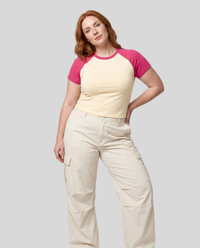Woman wearing the TrackLine Raglan Baby Tee in Apricot with Rose Red from the front showing its fitted cropped silhouette