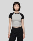 Woman wearing the TrackLine Raglan Baby Tee in Flower Gray with Black from the front showing its fitted cropped silhouette