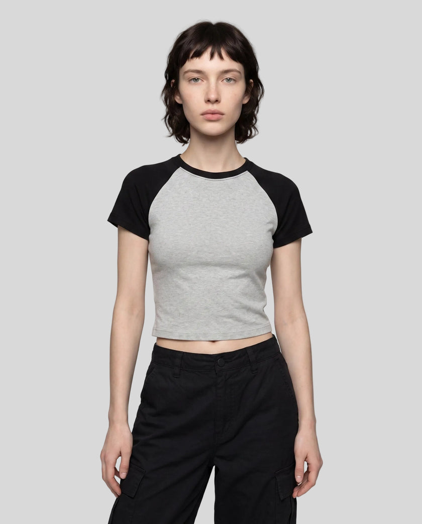 Woman wearing the TrackLine Raglan Baby Tee in Flower Gray with Black from the front showing its fitted cropped silhouette