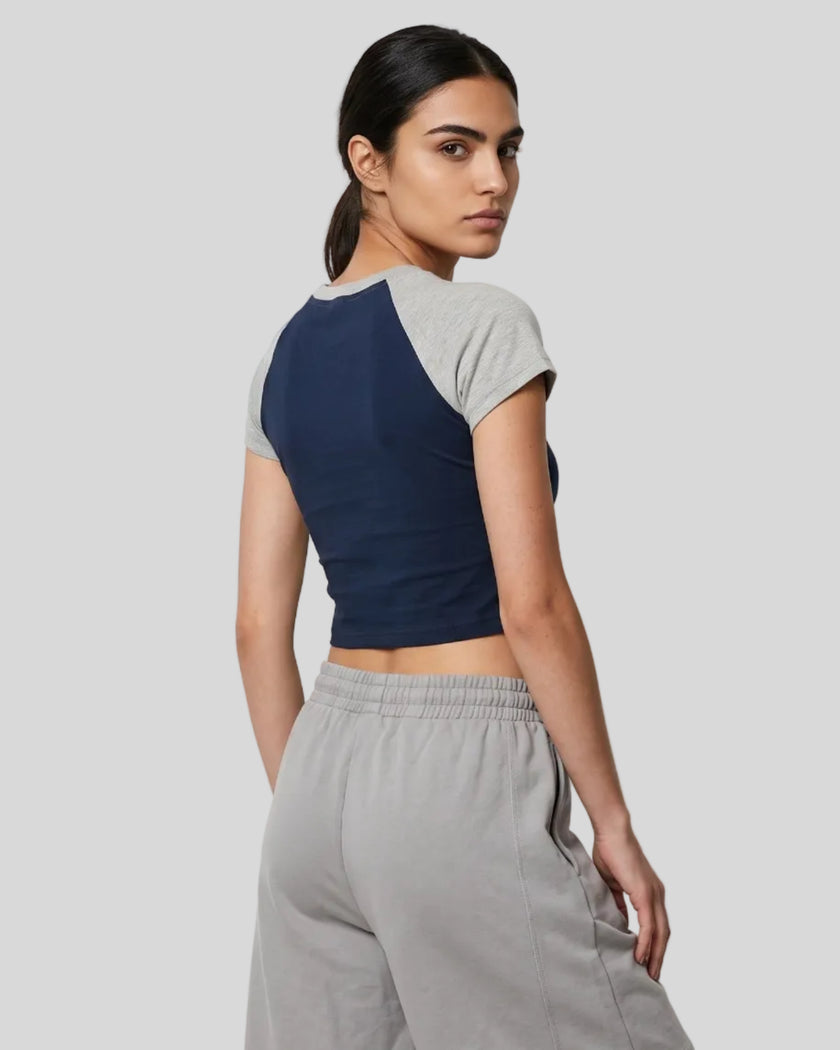 Woman wearing the TrackLine Raglan Baby Tee in Navy Blue with Flower Gray from the back showing its fitted shape and raglan construction