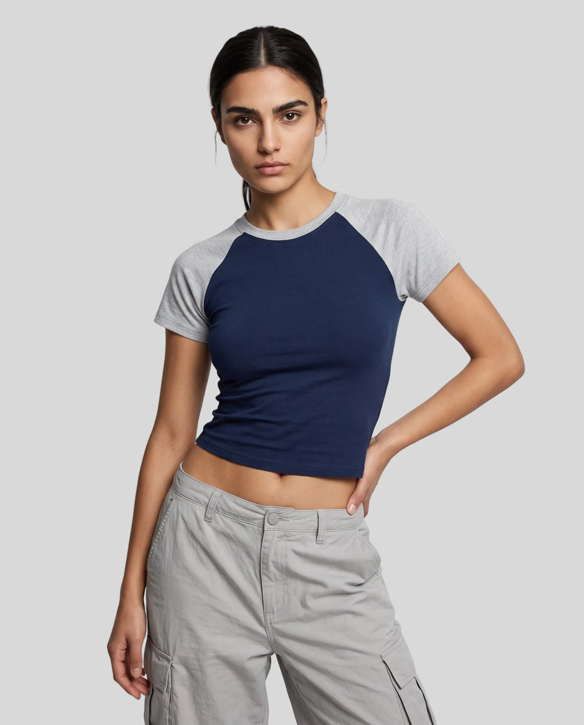 Woman wearing the TrackLine Raglan Baby Tee in Navy Blue with Flower Gray from the front showing its fitted cropped silhouette