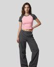 Woman wearing the TrackLine Raglan Baby Tee in Pink with Dark Gray from the front showing its fitted cropped silhouette